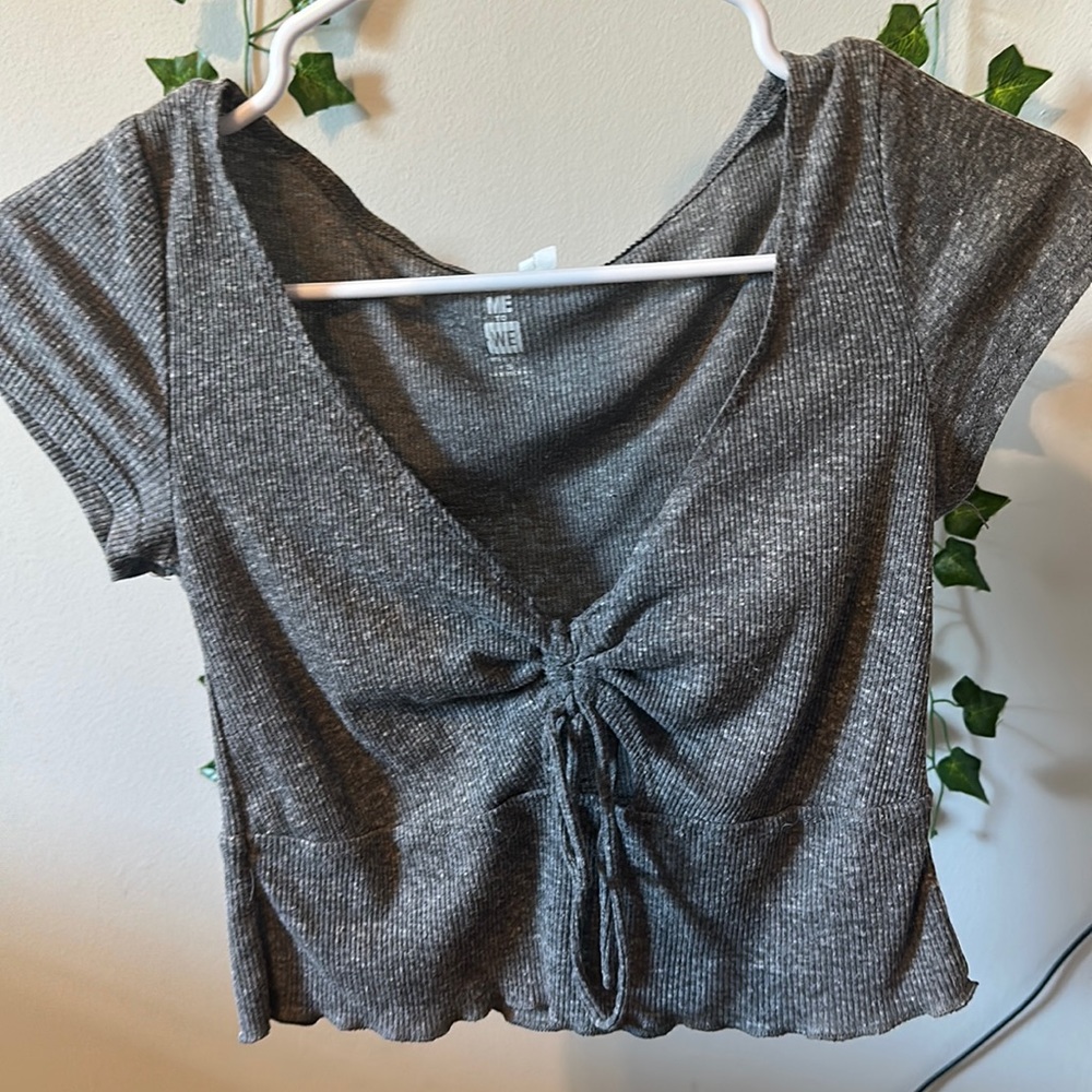 I am selling a gray T-shirt with a cut in the middle from me to we.